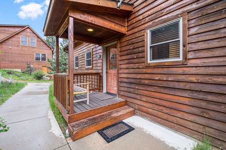 Exterior front door, with small porch and bench.