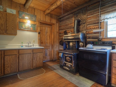 Kitchen with an oven and sink.  The antique stove is not operational.