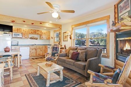 Three cushion sofa in the main living area, beautifully rustic log furniture, rocking chair, lovely stone gas fireplace.