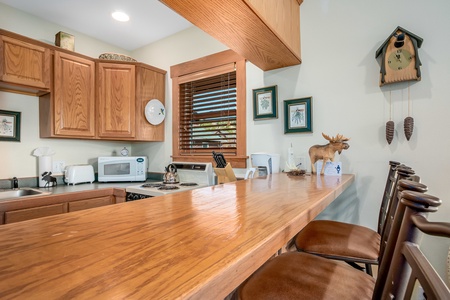 Bar-height counter-top seating for three guests in the kitchen area.