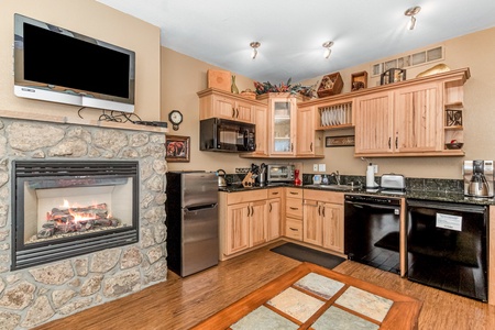 Beautiful stone gas fireplace adjacent to the efficiency kitchen.