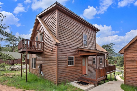 Exterior of cabin, with small patio on second floor, front door with small porch that wraps around to main deck.