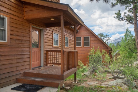 Exterior of cabin, front door with small covered porch.