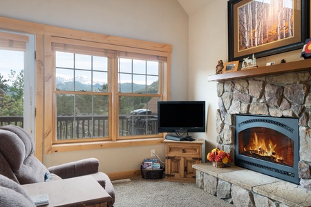 Living room with fireplace, flat screen TV, and 2 recliners.