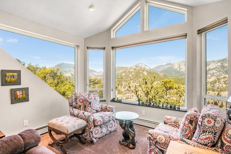 Sitting room surrounded by windows with beautiful mountain views