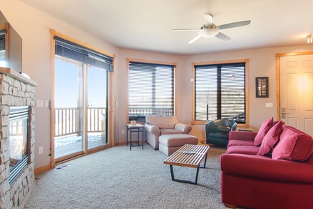 Queen sleeper sofa in the main living room, across from stone gas fireplace and sliding doors that open up to beautiful mountain views and the condo's private deck. 