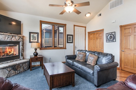 Main living area with comfortable Queen size sofa sleeper, gorgeous stone fireplace, and breathtaking mountain views from the large floor to ceiling windows.