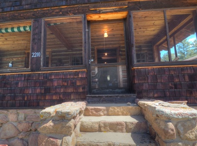 Stairs that lead to the screened in porch and front door