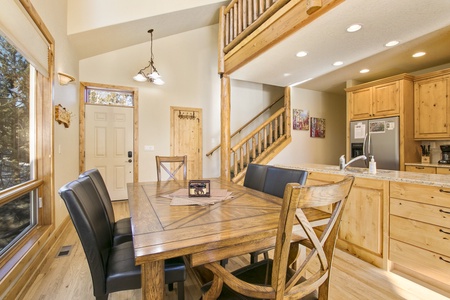 The dining area features a large dining table with six chairs