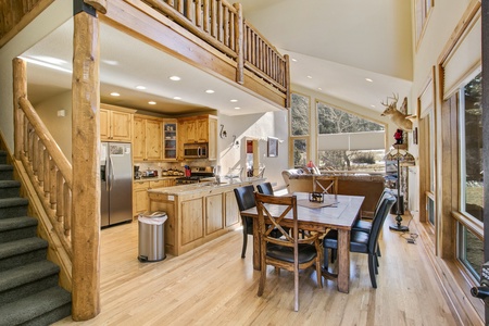 Enter into the open concept kitchen, dining, living area with beautiful cathedral ceilings