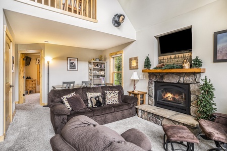 Bear themed living room with fireplace, sofa that seats 3, arm chair, and flat screen TV.