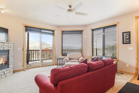 Queen sleeper sofa in the main living room, across from stone gas fireplace and sliding doors that open up to beautiful mountain views and the condo's private deck. 