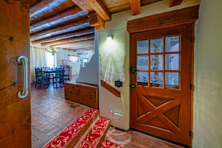 A wooden door leads to a dining room and kitchen.