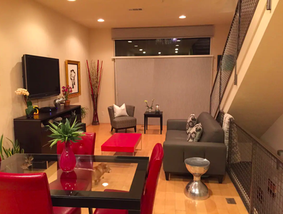 A living room with a table and chairs and a tv.