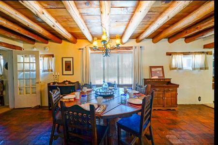 A dining room with a wooden table and chairs.