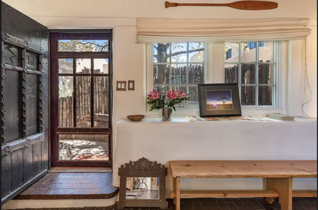 A room with a wooden bench and a window.