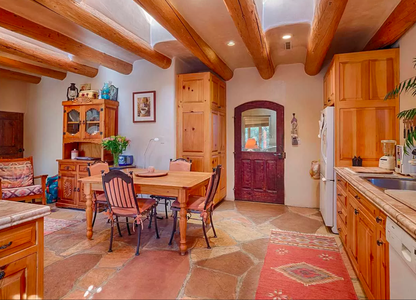 A kitchen with wooden beams and a dining table.