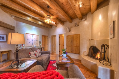A living room with a fireplace and wood beams.