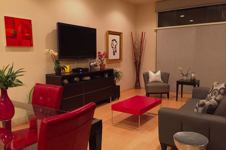 A living room with red furniture and a tv.