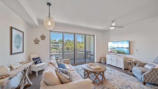 Unwind in the beautifully decorated coastal living room, featuring a comfortable sofa, large Smart TV, and direct access to your scenic balcony.