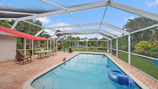 Spacious outdoor area with screened-in lanai patio and pool, perfect for cooling off and relaxing.