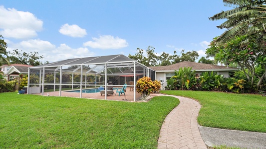 Tranquil backyard area with walkway to dock and canal for fishing and manatee viewing