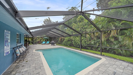 Large swimming pool perfect for families, friends, and children, in a screened in lanai.