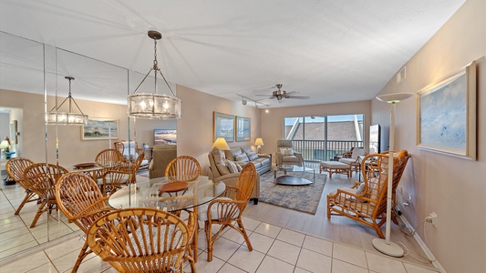 Spacious and open dining area with kitchen breakfast bar with additional seating, and an open living room with access to private screened in balcony.