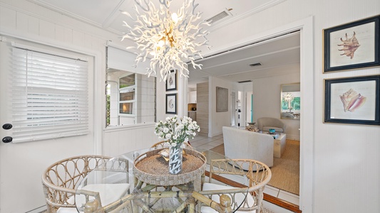 Enjoy meals together in the cozy sunlit dining area, designed with coastal decor and overlooking the private backyard oasis.