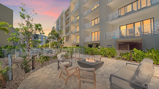 Relax outdoors by the cozy firepit overlooking the pool and grill area with gorgeous sunset views.