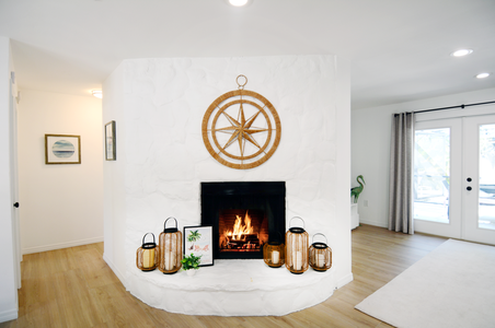 Cozy fireplace situated between the dinning room and living room area with patio and pool access