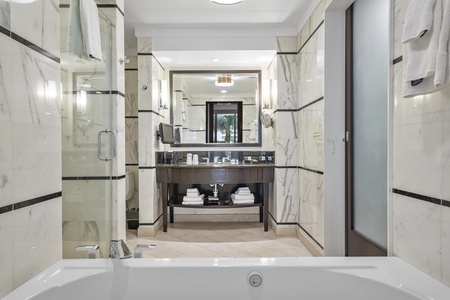 A marble-lined bathroom with a jetted spa tub