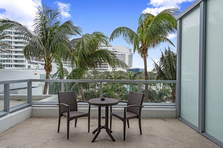 Large terrace overlooking the main pool area with tropical setting palm trees