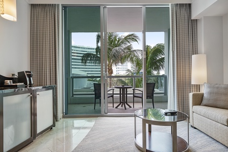 View from living area leading out to balcony with views of the tropical setting pool area