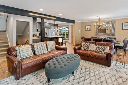 Brown couches, grey ottoman, white rug.