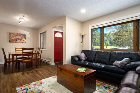 Black couch, brown table, dining table.