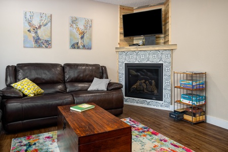 Black couch, fireplace, TV.