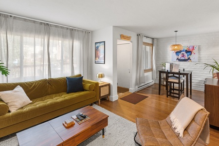 Yellow couch, brown chair, brown coffee table, grey rug.