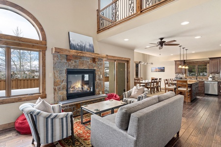 The beau!tiful, open floor plan with a gas fireplace, a medium sized couch, two chairs, and tow beanbags keeps friends and family together while eating and relaxing