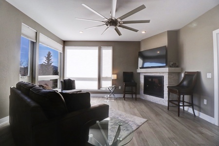 Open concept living room with large TV and fireplace.