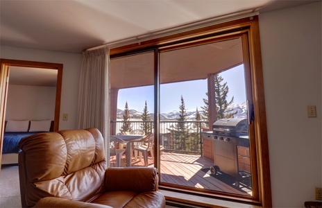 A cozy living room looking out onto the balcony with great views of Lake Dillon.