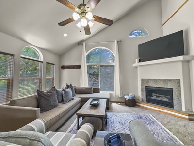 Open concept living area with high ceilings, TV, and fireplace!