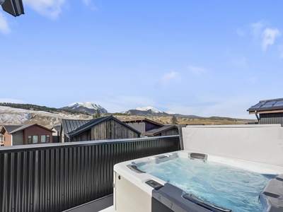 Private hot tub on the rooftop offers beautiful mountain views.