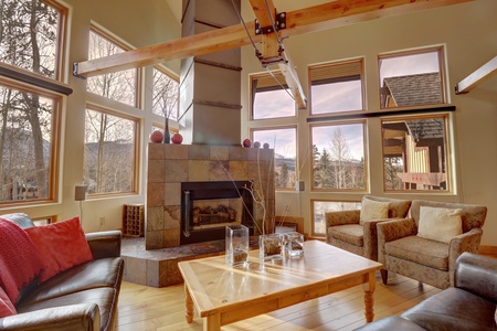 Beautiful living room with fireplace and large windows allowing ample natural light to come in.