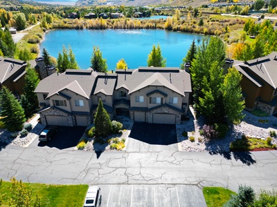 Aerial view of the townhome with a pond in the background.