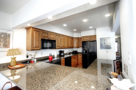 The kitchen has gorgeous granite counter-tops and wood cabinets.