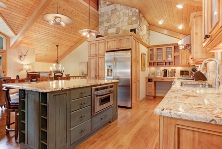 A kitchen with granite counter tops and a stainless steel refrigerator.