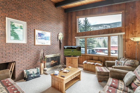 Open living room with brick walls and a wood burning fireplace