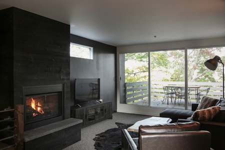 Living room with fireplace, with sliding doors to balcony.