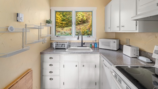 - Compact kitchen with window overlooking vibrant fall trees - Fully stocked with appliances for convenient cooking - Prepare meals while enjoying peaceful natural views